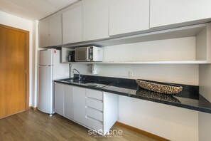 A kitchen with white cabinets, a black countertop, a microwave, and a sink. - Modern w/ Pool, 220m From the Beach Bpm0808 (Salvador)