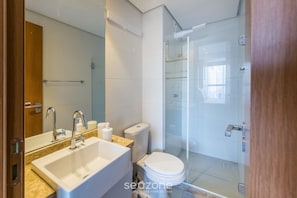 Ein modernes Badezimmer mit Waschbecken, Toilette und einer Duschkabine.