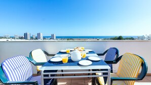 A dining table with chairs and a view of the sea and buildings. - The Sea Terrace - Rooftop Beach Duplex - Centre (Portimão)
