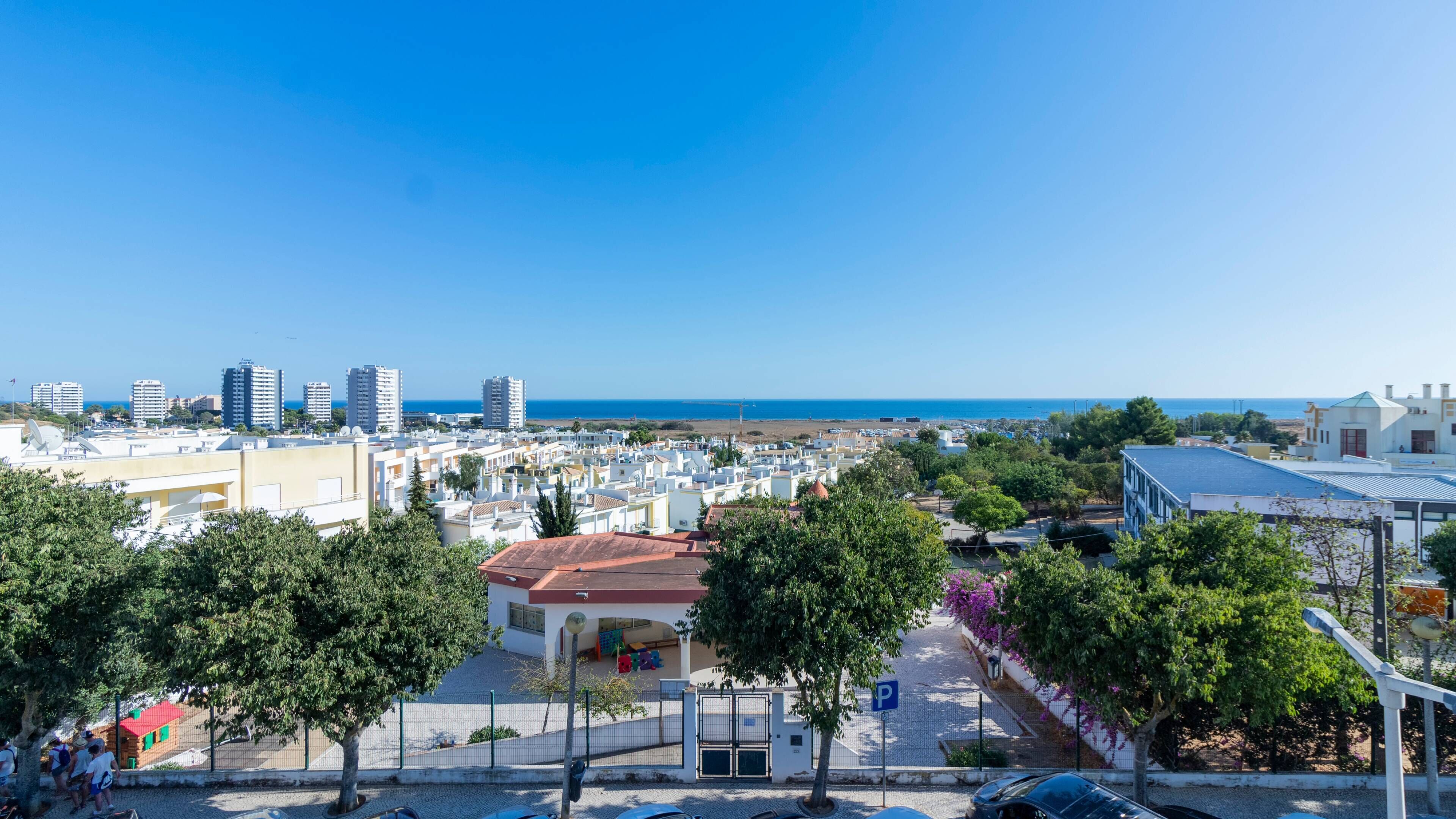 Paesaggio costiero con edifici, cielo sereno e vista sul mare.