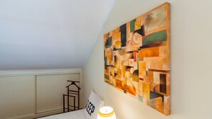 A room with a geometric abstract painting on the wall, a bedside table with a lamp, and a sign with the word 'SLEEP' on a pillow. - The Sea Terrace - Rooftop Beach Duplex - Centre (Portimão)