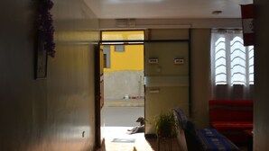A hallway with a tiled floor leading to a room with a bed and a window.