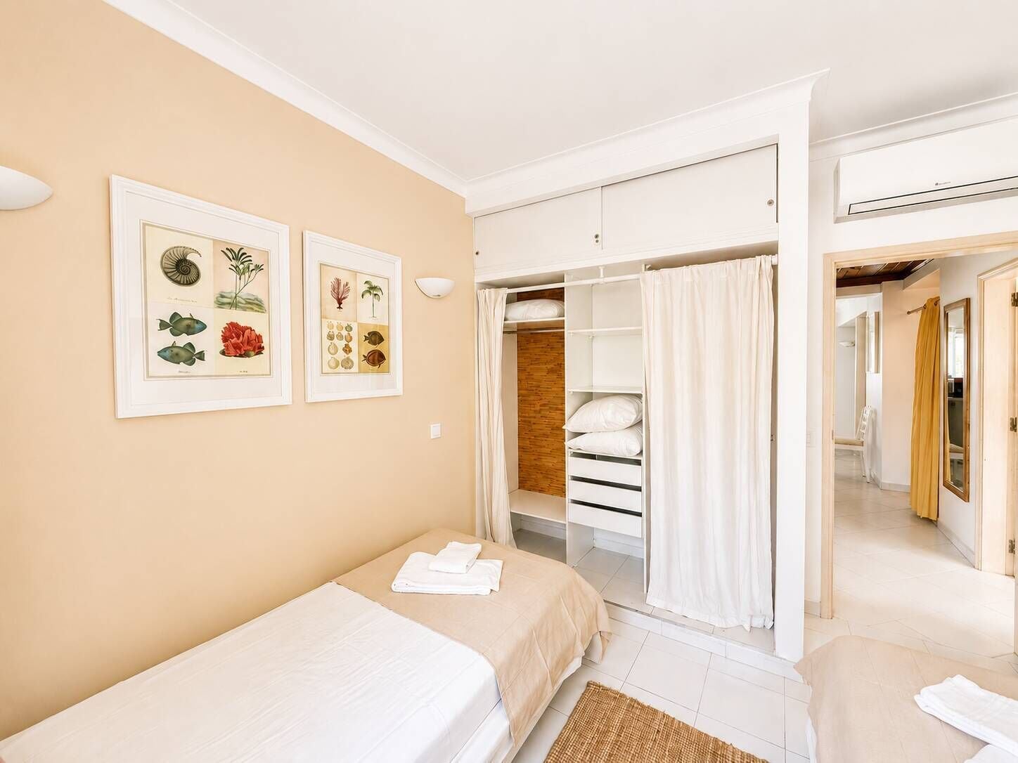 A bedroom with a bed, a wardrobe, and a bathroom visible through an open door.