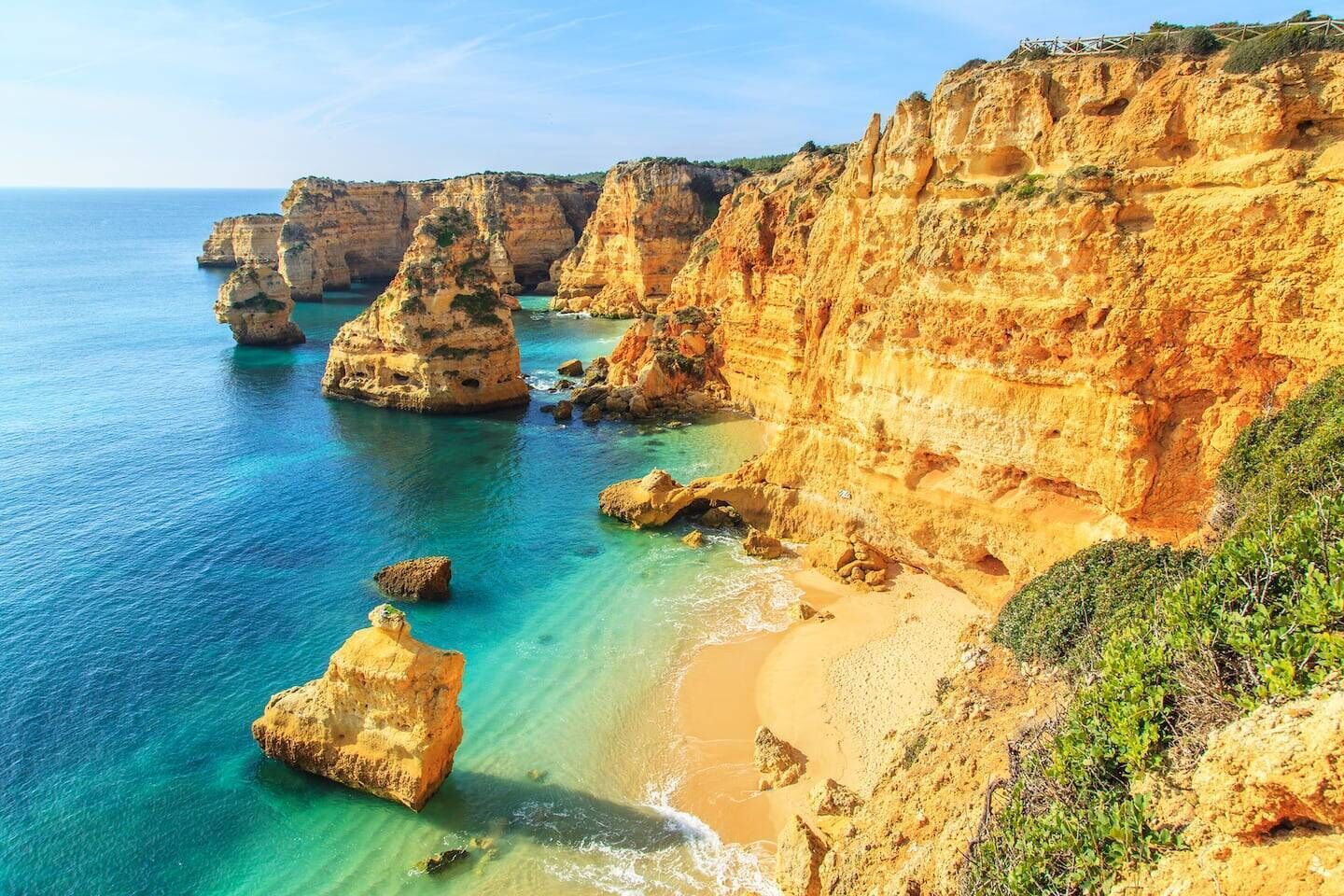 A coastal landscape with cliffs and clear blue waters.