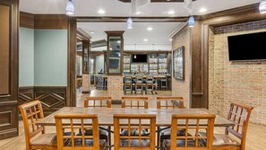 Un restaurante con pared de ladrillo, mesas y sillas de madera.