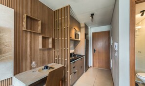 A modern bathroom with a wooden panel wall, a sink with a black countertop, and a shower area visible through a glass door. - Apt 220m From the sea in a Condo w/ a Pool Bpm0909 (Salvador)