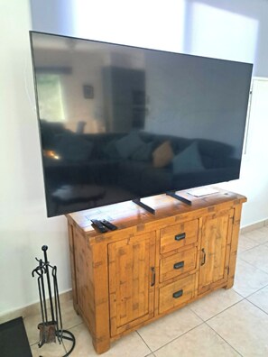 Ein Flachbildfernseher an einer Holzeinrichtung befestigt, mit einer Fernbedienung darauf.