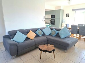 A living room with a grey sectional sofa, a coffee table, and patterned cushions. - Villa Ella - peaceful detached villa close to beach and mountains - Sleeps 6 (Argaka)