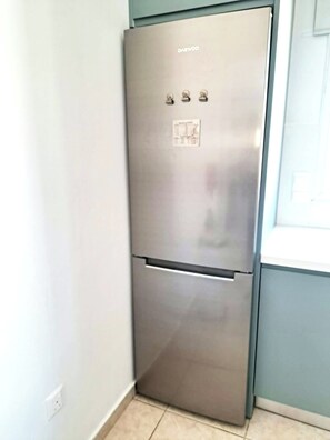 A stainless steel refrigerator in a kitchen with a light blue wall and a window. - Villa Ella - peaceful detached villa close to beach and mountains - Sleeps 6 (Argaka)