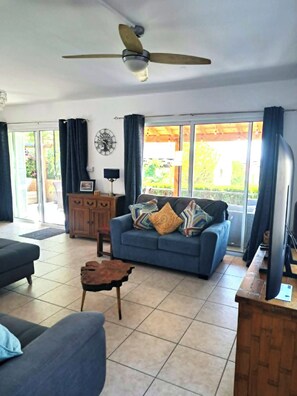 A living room with a ceiling fan, a sofa, a coffee table, and a cabinet. - Villa Ella - peaceful detached villa close to beach and mountains - Sleeps 6 (Argaka)