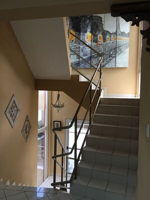 A staircase with a metal railing leading to a landing with a large framed picture. - Fabulous 4-bedroom house with AC in beautiful Las Croabas (Las Croabas)