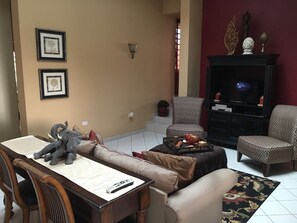 A living room with a sofa, armchair, and a television set. - Fabulous 4-bedroom house with AC in beautiful Las Croabas (Las Croabas)