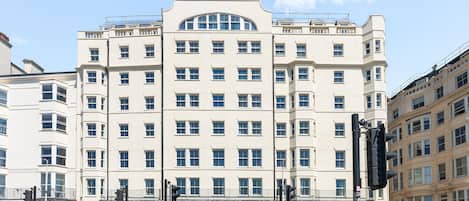 Un edificio de varios pisos con fachada simétrica, amplias ventanas y una entrada central.