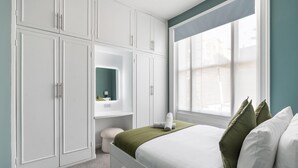 A bedroom with a bed, a window, and built-in storage cabinets. - Seaside Haven in Brighton (Brighton)