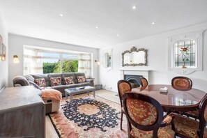 Ein geräumiges Wohnzimmer mit Sofa, Couchtisch und Essbereich mit Stühlen.