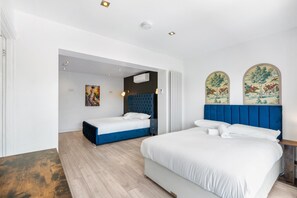 Ein modernes Schlafzimmer mit zwei Betten, einem großen Fenster und einem Bild an der Wand.