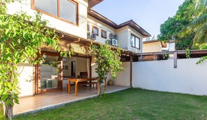 A two-story house with a patio area, outdoor furniture, and a small garden. - Apart in Condo w/ Barbecue Grill and Pool Cvb0110 (Maraú)