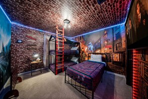 A room with a brick wall, a bunk bed, a desk, and a bookshelf. - Private Theater, Themed Rooms & Hot Tub (Davenport)