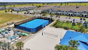 A residential complex with a fenced sports court, parking area, and a playground. - Private Theater, Themed Rooms & Hot Tub (Davenport)