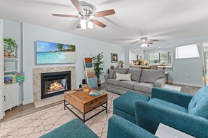 A modern living room with a fireplace, a sofa, a coffee table, and a ceiling fan. - W Hyde Pk 19B in Kingston 1st floor, Pool, Beach (Myrtle Beach)