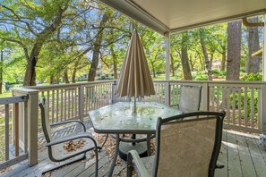 A covered outdoor seating area with a glass table and metal chairs, surrounded by a wooden deck and white railings. - W Hyde Pk 19B in Kingston 1st floor, Pool, Beach (Myrtle Beach)