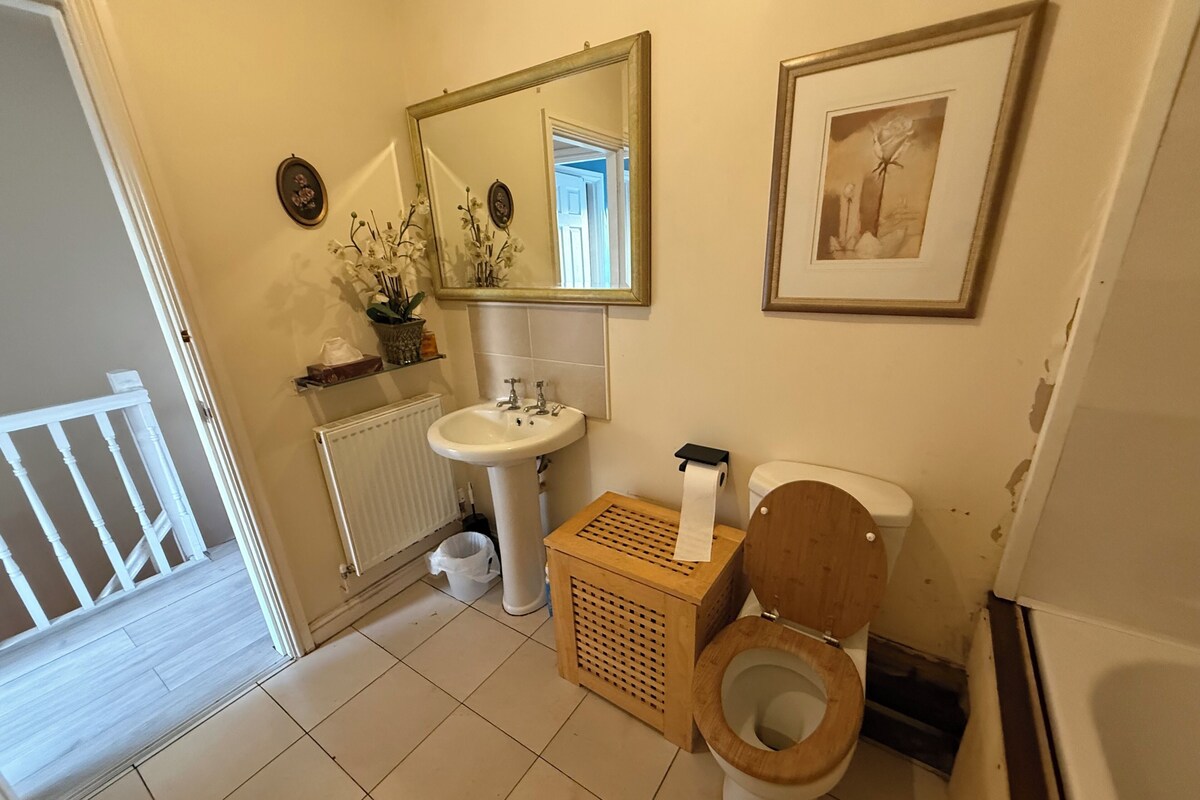 A bathroom with a toilet, sink, and mirror.