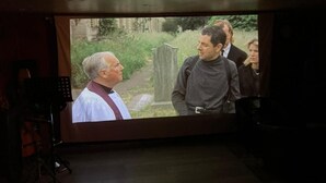 A projection screen with a scene of people outdoors. - Hotel Jacks Court (Ashton-under-Lyne)