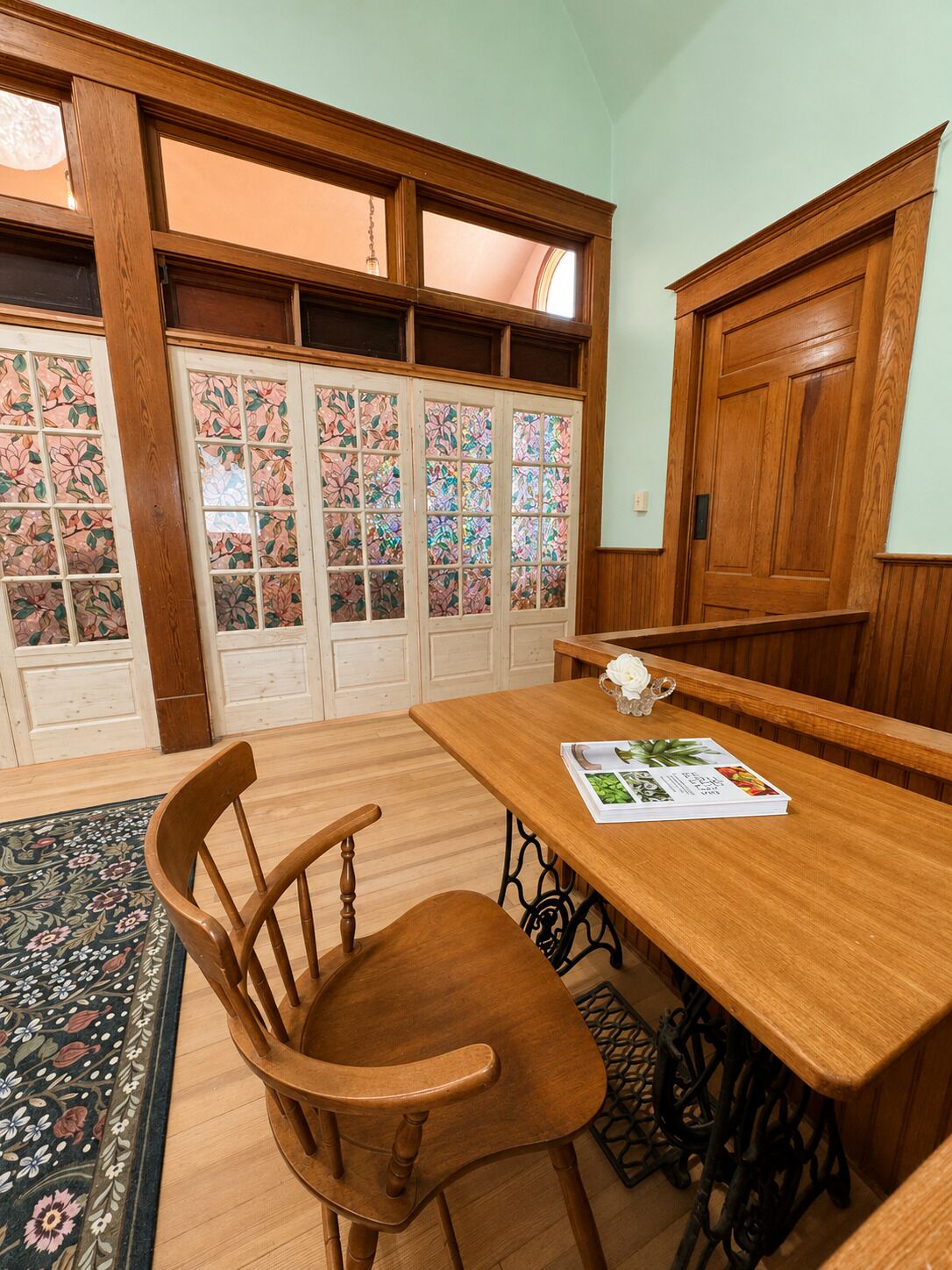 Una mesa de madera con una silla, un libro y un adorno encima.