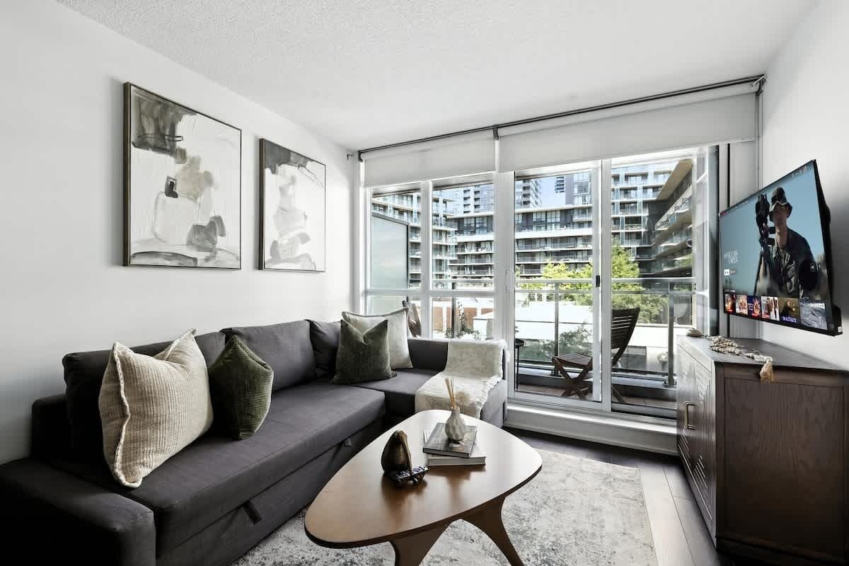 A modern living room with a sofa, coffee table, and artwork on the wall.
