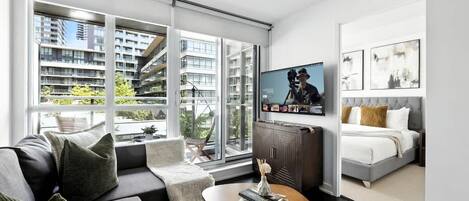 A modern living room with a sofa, coffee table, and a television mounted on the wall.