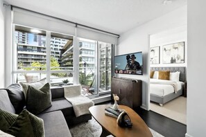 A modern living room with a sofa, coffee table, and a television mounted on the wall.