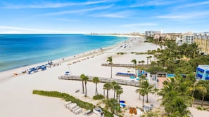 A beach resort with a long sandy shore, a wooden boardwalk, and a row of beachside buildings. - Siesta Sands - Unit 512 (Siesta Key)