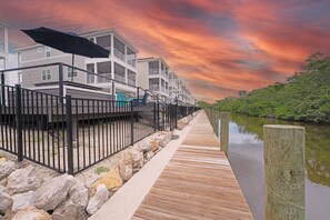 Una propiedad frente al río con una terraza de madera, barandal metálico y vistas al río.
