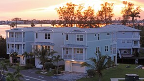 A multi-story residential building with a garage, a driveway, and a well-maintained lawn. - Hunters Point Resort and Marina Mainsail (Cortez)