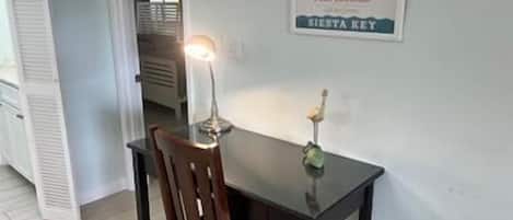 Un espace repas comprenant une table, une chaise et un panneau fixé au mur.