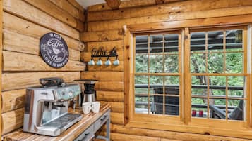 A rustic wooden interior with a coffee station featuring an espresso machine and a coffee grinder.