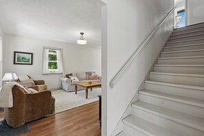 Un salon avec un canapé, une table basse et un escalier.