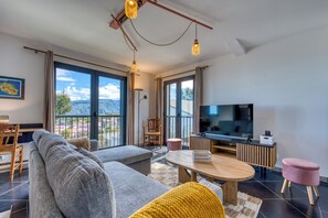 A modern living room with a sofa, a coffee table, a TV, and a view of the outdoors. - Ti Kaz Komela - Vue montagnes - Terrasse (Le Tampon)