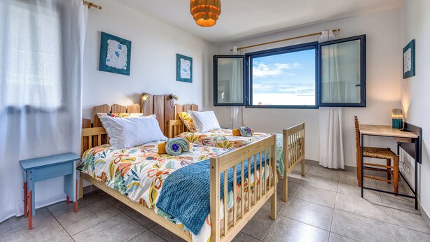 A bedroom with a bed, a desk, a chair, a window with a view, and artwork on the walls. - Ti Kaz Komela - Vue montagnes - Terrasse (Le Tampon)
