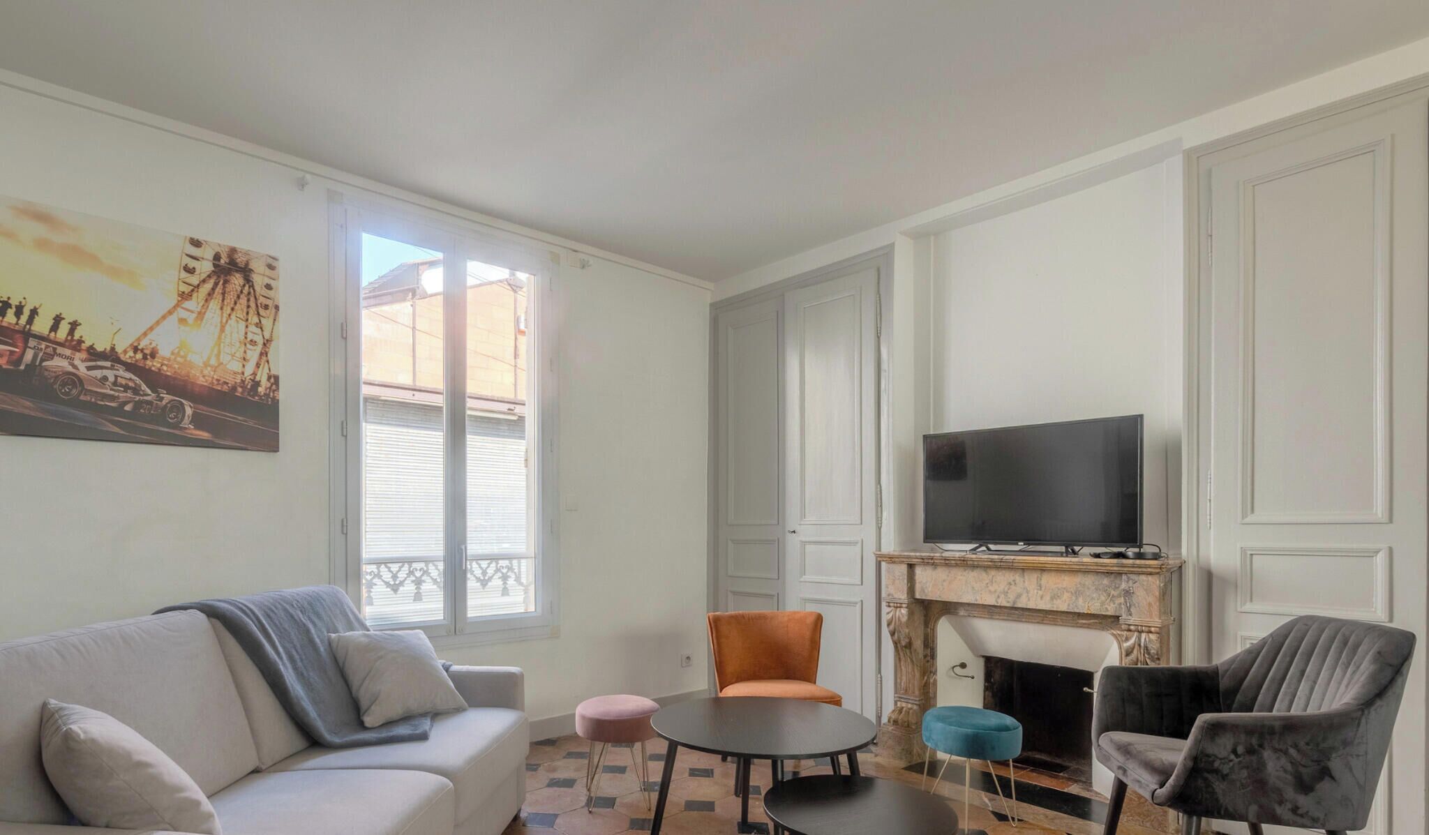 Ein Wohnzimmer mit einer Couch, Sesseln, einem kleinen Tisch, einem Fernseher und einem Kamin.