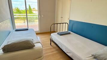Una habitación con dos camas, un ventanal grande y vistas a zonas verdes.