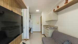 A compact living space with a kitchenette, a sofa, and a television. - Apt w/ Balcony 290 m From the Beach Hoa0308 (Salvador)