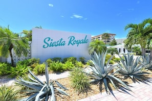 Une enseigne indiquant « Siesta Royale », avec un jardin tropical en premier plan.
