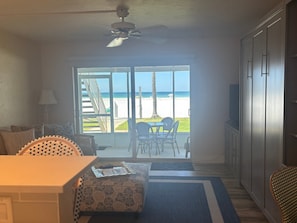 A room with a view of the beach, a ceiling fan, a dining table, and a sofa. - Gulf-front 1BR Siesta Key condo with king bed and sleeper sofa. (Siesta Key)