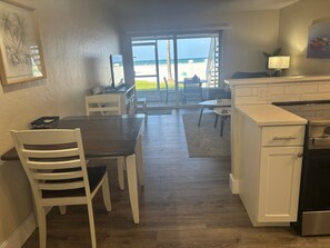A kitchen with a dining area, a view of the beach, and a large window. - Gulf-front 1BR Siesta Key condo with king bed and sleeper sofa. (Siesta Key)