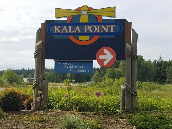 Opastekyltti, jossa lukee ”Kala Point” ja on nuoli, joka osoittaa oikealle, ja joka kertoo, että alue on portilla varustettu asuinalue.