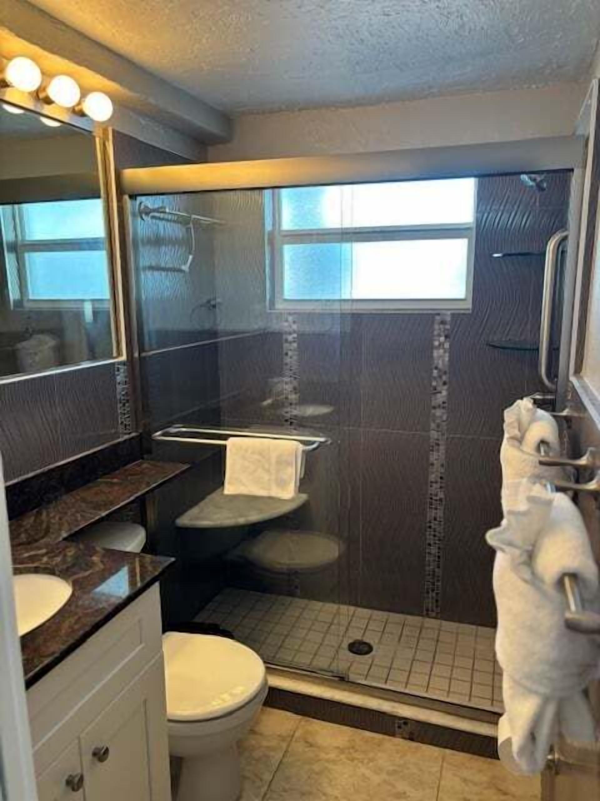 Un baño con ducha, inodoro y lavabo.