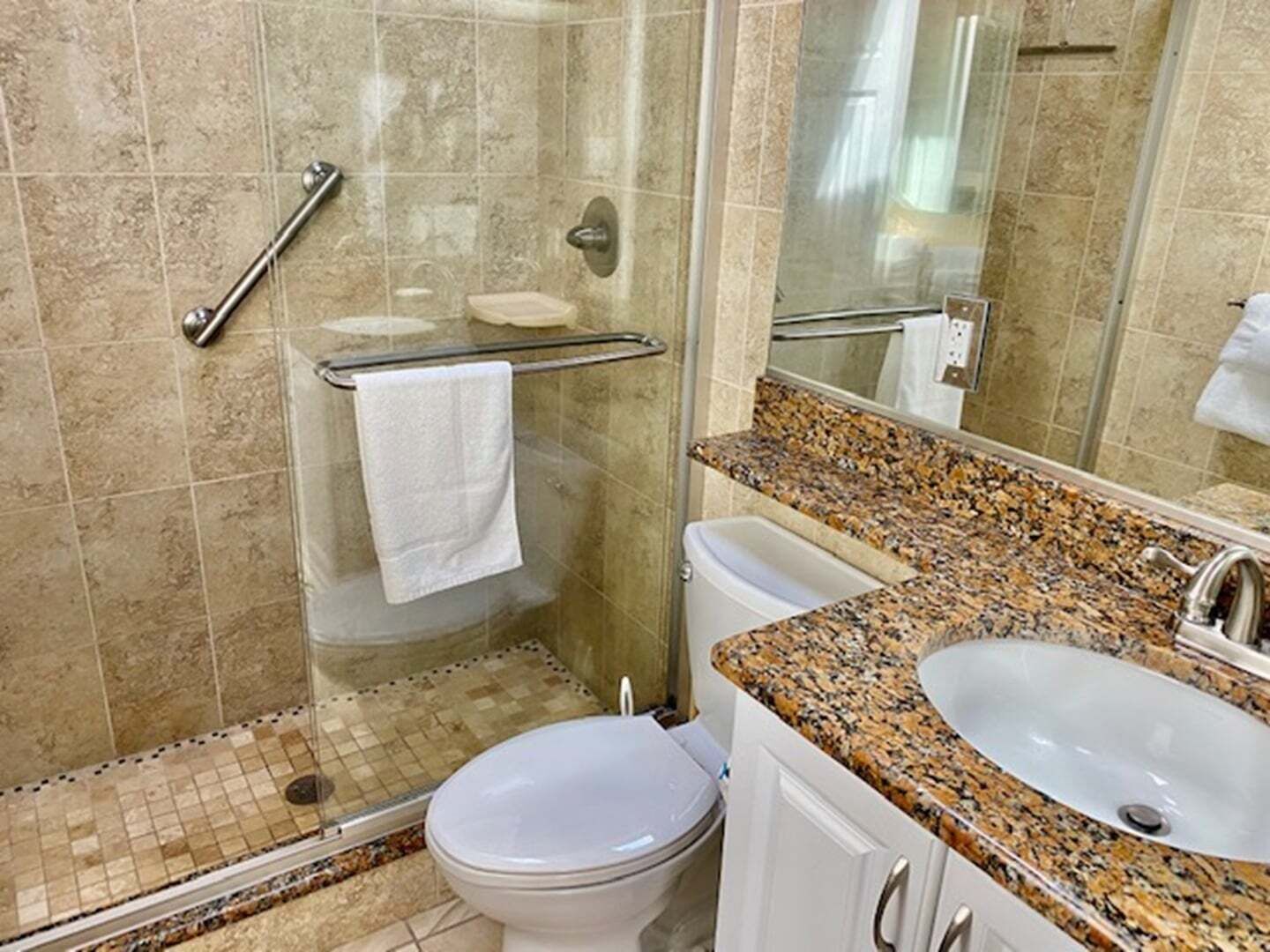 A bathroom with a shower, toilet, and sink.