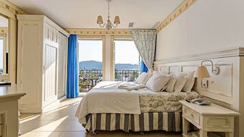 Quarto com cama, mesa de cabeceira e vista para o exterior.