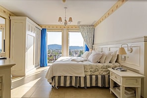 Ein Schlafzimmer mit Bett, Nachttisch und Blick ins Freie.
